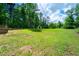 Large grassy backyard with treeline and shed in the distance at 550 Oglesby Bridge Se Rd, Conyers, GA 30094