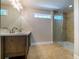 Bathroom featuring a glass shower, double sinks, and neutral tile at 550 Oglesby Bridge Se Rd, Conyers, GA 30094