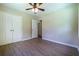 Bedroom featuring a ceiling fan, hardwood floors, neutral walls, and a double door closet at 550 Oglesby Bridge Se Rd, Conyers, GA 30094