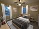 Bedroom featuring two sunny windows with curtains, rug, ceiling fan, and modern decor at 550 Oglesby Bridge Se Rd, Conyers, GA 30094