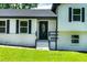 Close up of the home's entryway features a black door with decorative glass insert and black trim at 550 Oglesby Bridge Se Rd, Conyers, GA 30094