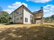 Rear view of a home with a covered patio featuring stone pillars and a spacious backyard at 1461 Leach Dr, Lawrenceville, GA 30045