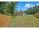 Expansive backyard of modern home surrounded by lush trees and a wooden fence for privacy at 1461 Leach Dr, Lawrenceville, GA 30045