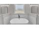 Elegant bathroom featuring a soaking tub and marble-style walls at 1461 Leach Dr, Lawrenceville, GA 30045