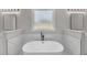Bright bathroom featuring a standalone tub, marble tiling, double vanity with large framed mirrors and modern lighting fixtures at 1461 Leach Dr, Lawrenceville, GA 30045
