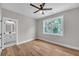 Bright bedroom with hardwood floors, ceiling fan, and a bathroom view through the open door at 1461 Leach Dr, Lawrenceville, GA 30045