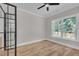 A spacious bedroom with hardwood floors, a modern ceiling fan, and a large window at 1461 Leach Dr, Lawrenceville, GA 30045