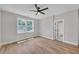 Bedroom with a ceiling fan, hardwood floors, and a bright window with green tree views at 1461 Leach Dr, Lawrenceville, GA 30045