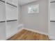 Spacious walk-in closet featuring custom built-in shelving and wood flooring at 1461 Leach Dr, Lawrenceville, GA 30045