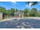 View of the gated entrance, featuring brick pillars, black metal gates, and a wooden fence surrounding the home at 1461 Leach Dr, Lawrenceville, GA 30045