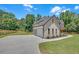 Home exterior featuring a three-car garage, new landscaping, a concrete driveway, and gray shingles at 1461 Leach Dr, Lawrenceville, GA 30045
