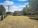 View of a home's backyard with a rustic wooden fence bordering the expansive lot at 1461 Leach Dr, Lawrenceville, GA 30045