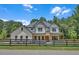 Beautiful two-story home with white brick, siding and a black wooden fence outlining the front yard at 1461 Leach Dr, Lawrenceville, GA 30045