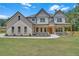 Stunning two-story home featuring a brick facade, covered porch with wooden beams, and professionally landscaped front yard at 1461 Leach Dr, Lawrenceville, GA 30045