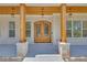 Close up of the front entrance featuring wooden columns, accent lighting, and a decorative wooden door at 1461 Leach Dr, Lawrenceville, GA 30045