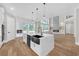 A modern open kitchen with a large island, stainless steel appliances, and a view into the living room at 1461 Leach Dr, Lawrenceville, GA 30045