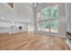 Open-concept living space with views of kitchen, a modern fireplace, lots of natural light and hardwood floors at 1461 Leach Dr, Lawrenceville, GA 30045