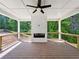 Covered deck featuring an outdoor fireplace, ceiling fan, and wood railings with natural views at 1461 Leach Dr, Lawrenceville, GA 30045