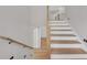 Bright staircase featuring hardwood steps, white risers, and modern wooden handrails at 1461 Leach Dr, Lawrenceville, GA 30045