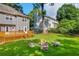 Grassy backyard featuring a wooden deck, stone fire pit, and mature trees at 2151 Hamstead Ct, Suwanee, GA 30024