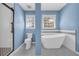 Bright bathroom showcasing a soaking tub, toilet, and a glass-enclosed shower with sleek fixtures at 2151 Hamstead Ct, Suwanee, GA 30024