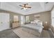 Primary bedroom featuring tray ceilings, a ceiling fan, and plush carpeting at 2151 Hamstead Ct, Suwanee, GA 30024