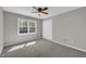 Bright bedroom with a ceiling fan, neutral walls, and a window letting in natural light at 2151 Hamstead Ct, Suwanee, GA 30024