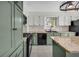 Well-lit kitchen featuring modern appliances and green cabinets with granite counters at 2151 Hamstead Ct, Suwanee, GA 30024