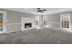 Spacious living room with soft carpeting, a stone fireplace, and ample natural light at 2151 Hamstead Ct, Suwanee, GA 30024
