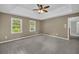 Bright main bedroom featuring a tray ceiling, carpet floors, and large windows allowing plenty of natural light at 2151 Hamstead Ct, Suwanee, GA 30024