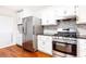 Well-equipped kitchen featuring stainless steel appliances, white cabinets, granite countertops, and stylish backsplash at 2901 Lenox Ne Way # 902, Atlanta, GA 30324