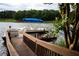 Dock featuring a pontoon boat and wooden railing with lake views, surrounded by green plants and foliage at 3800 Schooner Rdg, Alpharetta, GA 30005