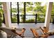 Inviting lake view porch featuring wood chairs and peaceful wooded scenery at 3800 Schooner Rdg, Alpharetta, GA 30005