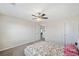Spacious bedroom with a ceiling fan, carpeted floor, and natural light from the open window at 522 Spring View Dr, Woodstock, GA 30188