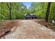 Scenic view of a modern farmhouse with dark gray siding nestled in a lush green wooded area at 1687 Harmony Rd, Temple, GA 30179