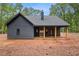Rear view of new construction home featuring a covered patio and a spacious yard at 1687 Harmony Rd, Temple, GA 30179