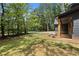 Craftsman home with a side porch, lush green lawn and wooded backdrop at 1687 Harmony Rd, Temple, GA 30179