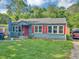 View of the exterior showcasing the blue home with red shutters and a well-maintained lawn at 2404 Shallowford Ter, Atlanta, GA 30341