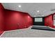 Finished basement with red walls and a projector screen, perfect for a home theater setup at 2990 Hearthstone Dr, Cumming, GA 30041