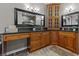 Elegant bathroom with dark granite countertops, dual sinks, framed mirrors, and wooden cabinetry at 2990 Hearthstone Dr, Cumming, GA 30041