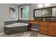 Modern bathroom with soaking tub, granite countertops, framed mirror, and natural light at 2990 Hearthstone Dr, Cumming, GA 30041