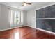 This bedroom features hardwood floors, a ceiling fan, and a chalkboard wall for customizable creativity at 2990 Hearthstone Dr, Cumming, GA 30041