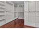 Walk-in closet featuring custom shelving and hardwood floors at 2990 Hearthstone Dr, Cumming, GA 30041