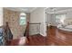 Hallway featuring stone accent wall, wood floors, iron railing and view into main bedroom with a trey ceiling at 2990 Hearthstone Dr, Cumming, GA 30041