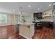 Kitchen island with seating, dark wood cabinetry, and granite countertops at 2990 Hearthstone Dr, Cumming, GA 30041