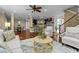 Open concept living room with wood floors, decorative rug, and views of the kitchen and dining area at 2990 Hearthstone Dr, Cumming, GA 30041