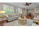 Spacious living room with many windows, a large couch and stylish decor leading into the dining area at 2990 Hearthstone Dr, Cumming, GA 30041