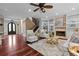 Bright living room featuring a fireplace, built-in shelving, wood floors, and staircase at 2990 Hearthstone Dr, Cumming, GA 30041