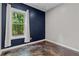 Cozy room featuring a dark blue accent wall, window with natural light, and unique flooring at 2990 Hearthstone Dr, Cumming, GA 30041
