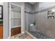Bathroom featuring a modern shower with pebble floor, sitting ledge, gray tile, and glass door at 2990 Hearthstone Dr, Cumming, GA 30041